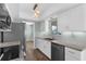 Modern kitchen with white cabinets, stainless steel appliances, granite countertops, and stylish pendant lighting at 913 64Th W St, Bradenton, FL 34209
