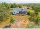 Aerial view of the property showcasing the home, large deck, and backyard fire pit area at 10001 289Th E St, Myakka City, FL 34251