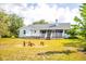 Backyard with firepit and seating behind home featuring screened porch at 10001 289Th E St, Myakka City, FL 34251