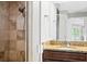 Bathroom with tiled shower and a granite-topped vanity with sink at 10001 289Th E St, Myakka City, FL 34251