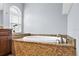 Closeup of the tub with granite surround, arched window and blinds at 10001 289Th E St, Myakka City, FL 34251