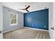 Bedroom with a navy accent wall, ceiling fan, and a large window at 10001 289Th E St, Myakka City, FL 34251