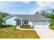 Charming single-story home features a well-manicured lawn, a two-car garage, and colorful landscaping at 10001 289Th E St, Myakka City, FL 34251