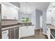 Contemporary kitchen featuring stainless steel appliances, white cabinets, laminate flooring, and stylish backsplash at 10001 289Th E St, Myakka City, FL 34251