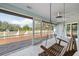 Relaxing screened porch with a swing and ceiling fans, offering a serene outdoor living space at 10001 289Th E St, Myakka City, FL 34251