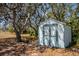 Outdoor shed for storage on a tree-lined property with well-kept grounds at 10001 289Th E St, Myakka City, FL 34251