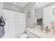The neutral-toned bathroom features a vanity with a white countertop and shower with a curtain at 1017 Fernleaf Run, Bradenton, FL 34212