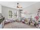 Cozy bedroom featuring two windows, a ceiling fan, neutral walls, and plenty of space for toys at 1017 Fernleaf Run, Bradenton, FL 34212