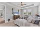 Bedroom featuring tray ceiling, carpet, and two windows at 1017 Fernleaf Run, Bradenton, FL 34212