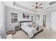 Bedroom featuring tray ceiling, carpet, and two windows at 1017 Fernleaf Run, Bradenton, FL 34212