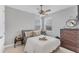 This neutrally decorated bedroom includes a ceiling fan and dresser at 1017 Fernleaf Run, Bradenton, FL 34212