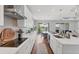 Long shot of well-designed kitchen with stainless steel appliances, island, and white cabinets at 1017 Fernleaf Run, Bradenton, FL 34212
