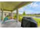 Covered brick patio featuring a grill and a peaceful water view at 1017 Fernleaf Run, Bradenton, FL 34212
