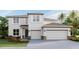 Two-story home featuring a neutral color palette, attached two-car garage, and manicured landscaping at 10709 Tippecanoe Pl, Parrish, FL 34219
