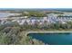 Aerial view of homes along a lake, surrounded by lush landscaping and water features at 12091 Firewheel Pl, Venice, FL 34293
