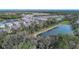 Scenic aerial view of homes bordering a lake and lush wooded areas, creating a peaceful setting at 12091 Firewheel Pl, Venice, FL 34293