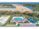 Overhead view of the community pool, clubhouse, bocce ball, and tennis courts at 12091 Firewheel Pl, Venice, FL 34293
