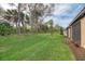 Large grassy backyard with mature trees along property line and exterior of home at 12091 Firewheel Pl, Venice, FL 34293