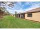 Spacious backyard with lush lawn, complemented by a screened porch and trees at 12091 Firewheel Pl, Venice, FL 34293