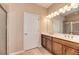 Bathroom with double vanity, wood cabinets, a large mirror, and a shower at 12091 Firewheel Pl, Venice, FL 34293