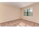 Well-lit bedroom featuring a window and neutral carpet, paint, and trim at 12091 Firewheel Pl, Venice, FL 34293
