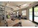 Well-equipped fitness center with various machines, ceiling fans, and a view of the pool at 12091 Firewheel Pl, Venice, FL 34293