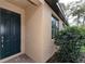 Inviting home exterior showcasing a dark front door, window, and manicured landscaping at 12091 Firewheel Pl, Venice, FL 34293