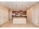Modern kitchen features a granite island, stainless steel appliances, and custom wood cabinetry at 12091 Firewheel Pl, Venice, FL 34293
