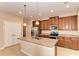 Modern kitchen features a granite island, stainless steel appliances, and custom wood cabinetry at 12091 Firewheel Pl, Venice, FL 34293