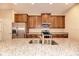 Modern kitchen showcasing granite countertops, stainless steel appliances, and wooden cabinets at 12091 Firewheel Pl, Venice, FL 34293