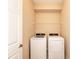 Bright laundry room featuring a white washer and dryer with shelving above for extra storage at 12091 Firewheel Pl, Venice, FL 34293