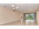 Open living room with tiled floors, recessed lighting, and sliding glass doors to the outdoors at 12091 Firewheel Pl, Venice, FL 34293