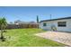 Lush backyard featuring a grassy area, wooden fence, and brick-paved patio at 1227 Porpoise Rd, Venice, FL 34293