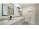 Modern bathroom with a vanity, floating shelves, and a tiled walk-in shower at 1227 Porpoise Rd, Venice, FL 34293