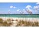 Beautiful beach scene with clear turquoise water, white sand, and sea oats under a bright blue sky at 1227 Porpoise Rd, Venice, FL 34293
