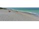 Expansive beach view of white sand, teal water and people enjoying a relaxing day at 1227 Porpoise Rd, Venice, FL 34293