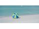 Relaxing beach scene with a colorful beach umbrella by the tranquil turquoise water at 1227 Porpoise Rd, Venice, FL 34293