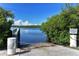 Concrete boat ramp leading into calm waters with lush vegetation on either side at 1227 Porpoise Rd, Venice, FL 34293