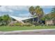 Unique building exterior with a wing-shaped roof, surrounded by lush landscaping and palm trees at 1227 Porpoise Rd, Venice, FL 34293