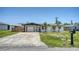 Inviting single-story home with a well-manicured lawn and driveway leading to an attached garage at 1227 Porpoise Rd, Venice, FL 34293