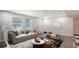 Bright living room featuring neutral tones, a tufted sofa, and large windows for natural light at 1227 Porpoise Rd, Venice, FL 34293
