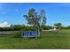 Signage for South Venice Beach Ferry surrounded by a grassy field and tall trees at 1227 Porpoise Rd, Venice, FL 34293