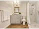 This bathroom features a marble tiled shower, vanity with mirror, and wood-look floors at 13 Oak St, Bradenton, FL 34208