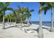 Beautiful beach with white sand, lounge chairs, palm trees, and picturesque waterfront views at 13 Oak St, Bradenton, FL 34208