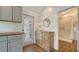 This charming entryway features a decorative cabinet, a small lamp, and access to a stylish bathroom with tiled shower at 13 Oak St, Bradenton, FL 34208