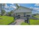 White building with blue doors and black benches in a well-maintained, grassy area at 13 Oak St, Bradenton, FL 34208