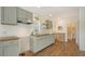 This kitchen has grey cabinets, wood countertops, shiplap walls, and wood-look floors, giving it a modern farmhouse aesthetic at 13 Oak St, Bradenton, FL 34208