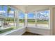 Inviting sunroom with expansive windows and natural light, showcasing neighborhood views and wood-look floors at 13 Oak St, Bradenton, FL 34208
