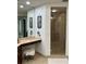 Elegant bathroom boasts a glass-enclosed shower, dual vanity with a makeup table, and decorative mirrors at 130 Riviera Dunes Way # 304, Palmetto, FL 34221