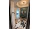 Stylish entryway featuring an animal print rug, elegant lighting fixture, and view of the open-concept living space at 130 Riviera Dunes Way # 304, Palmetto, FL 34221